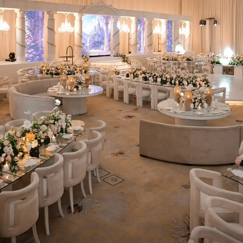 Cream lounge sofas and flower-dressed tables across a ballroom with painted garden backdrops
